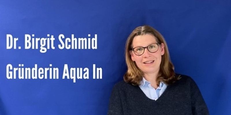 Portrait der Gründerin von Aqua In, Dr. Birgit Schmid, vor blauem Hintergrund. Auf dem Bild steht, Dr. Birgit Schmid Gründerin von Aqua In.